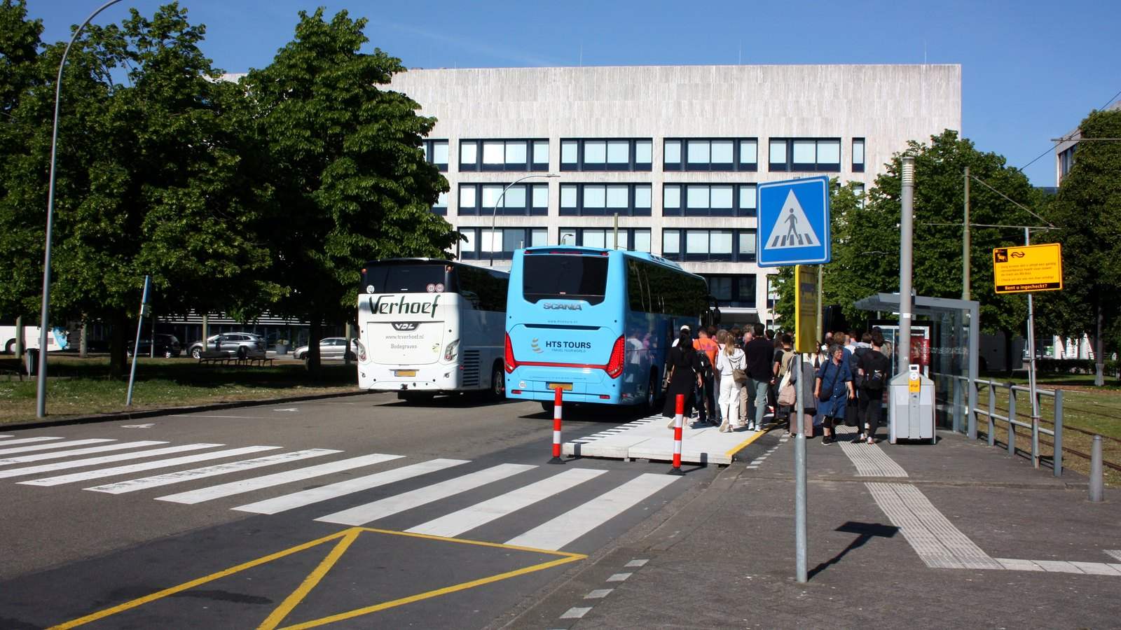 Twee treinvervangende bussen met wachtende reizigers voor een Nederlands station